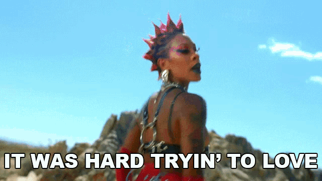 a woman with a mohawk stands in front of a mountain with the words " it was hard tryin ' to love " written below her