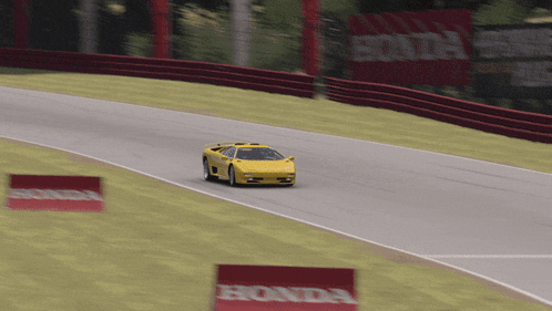 a yellow sports car is driving down a track