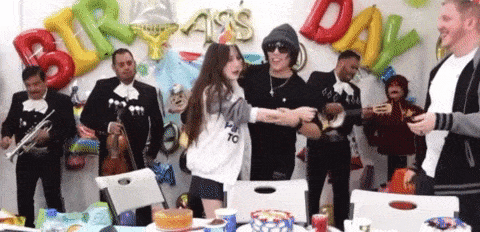a group of people are dancing in front of balloons that say " birthday "