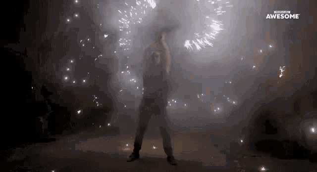 a man is standing in front of a fireworks display and the words awesome are on the bottom of the screen