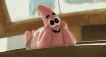 a stuffed animal of patrick star from spongebob squarepants is laying on a ledge .