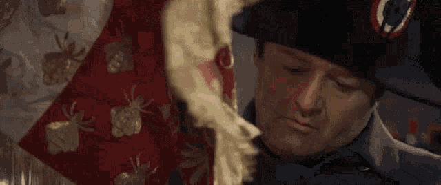 a man in a napoleon hat is holding a red and white blanket .