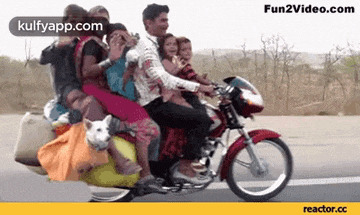 a man is riding a motorcycle with a dog on the back .