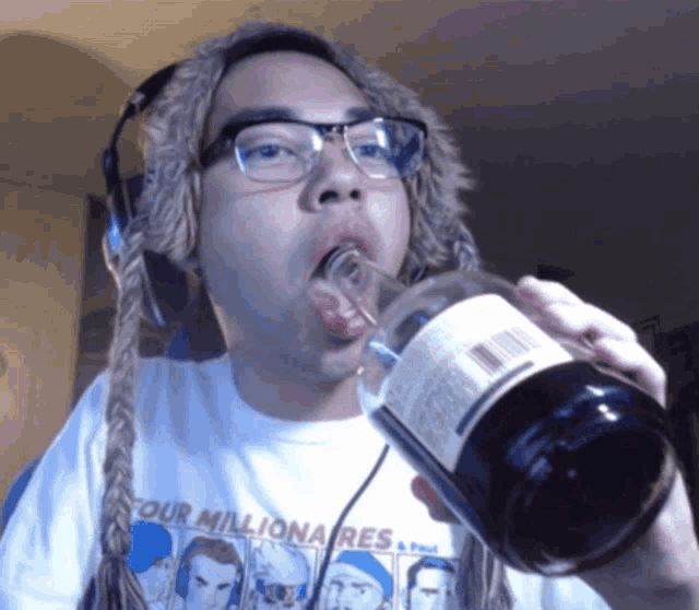 a man wearing a shirt that says four millionaires drinks from a bottle