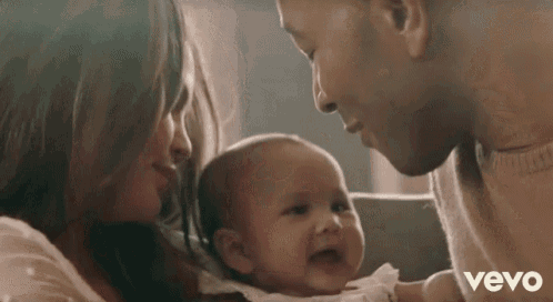 a man and a woman are holding a baby .