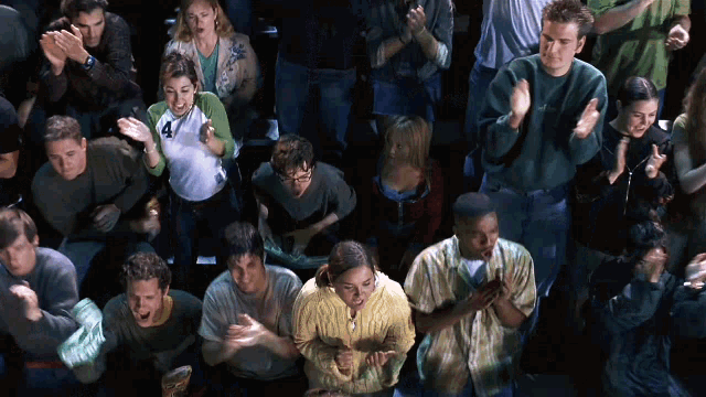 a woman wearing a white shirt with the number 4 on it stands in a crowd of people