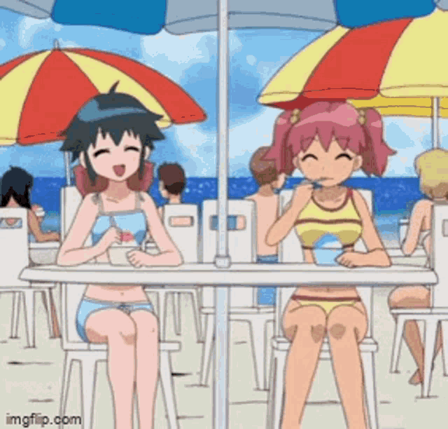 two girls in bikinis are sitting at a table under umbrellas on a beach .