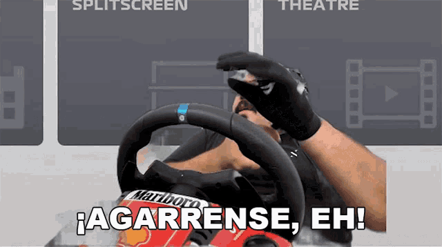 a man holding a steering wheel with the words agarrense eh on it