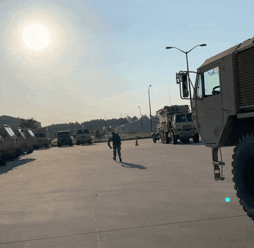 a man walking in front of a military vehicle with the letters psn on it