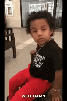 a little boy is sitting on a chair in a waiting room .