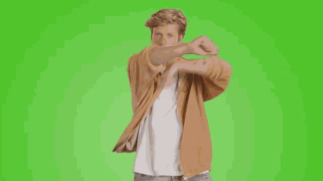 a man wearing a brown jacket and a white shirt is making a stop sign