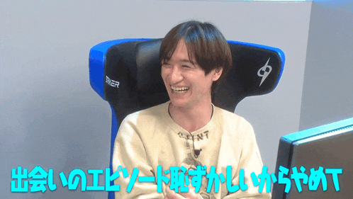 a man wearing a shirt that says saint is sitting in front of a monitor
