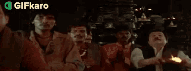 a man is dancing in a bar with his arms outstretched in a crowd of people .