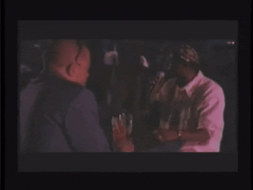 a group of men are sitting at a table in a dark room