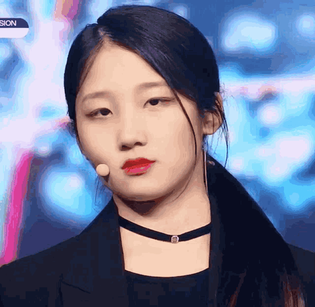 a close up of a woman wearing a choker and a microphone
