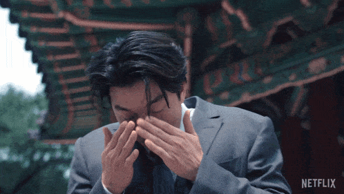 a man in a suit has his hands on his head and the word netflix is on the bottom of the image