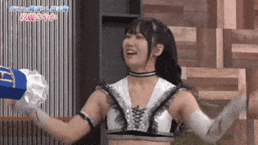 a woman in a wrestling outfit is smiling and holding a boxing glove that says t on it
