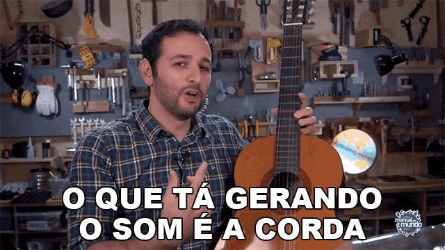 a man in a plaid shirt is holding a guitar and says o que ta gerando