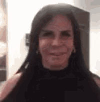 a close up of a woman 's face with long black hair .
