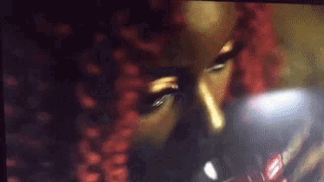 a close up of a woman with red hair drinking from a glass .