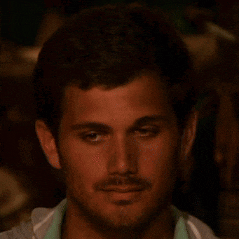 a man with a beard is looking at the camera with a serious look on his face