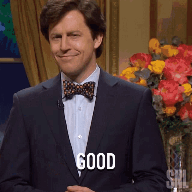 a man in a suit and bow tie says " good "