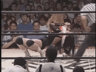a woman is wrestling another woman in a ring while a referee looks on .