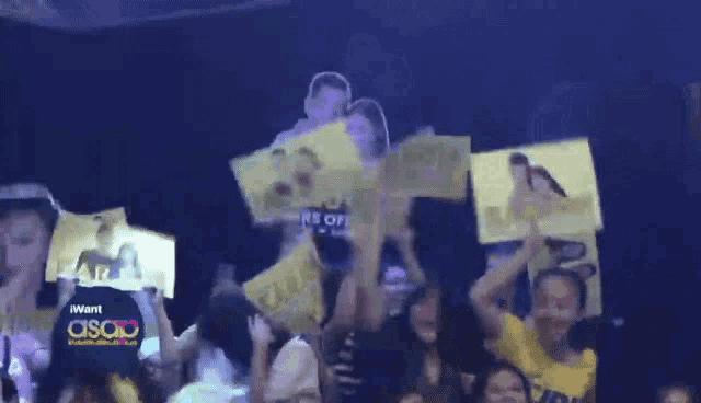 a crowd of people holding up signs that say asap on them