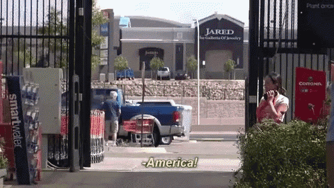 a woman is talking on a cell phone in front of a store that says jared