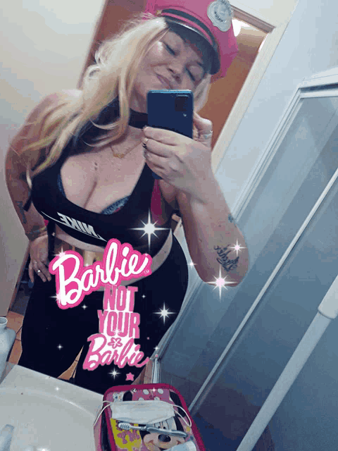 a woman taking a picture of herself in a mirror with a barbie nut your barbie sticker