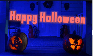 a sign that says happy halloween with pumpkins in front of it