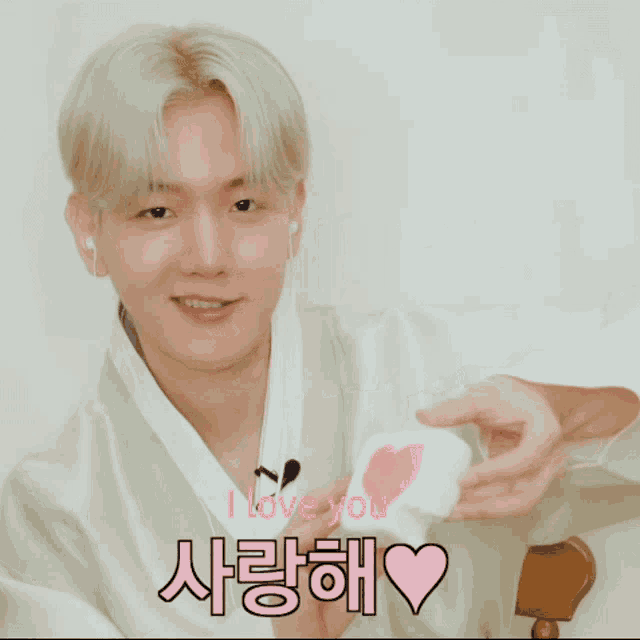 a man holding a piece of paper with a heart on it and the words i love you in pink