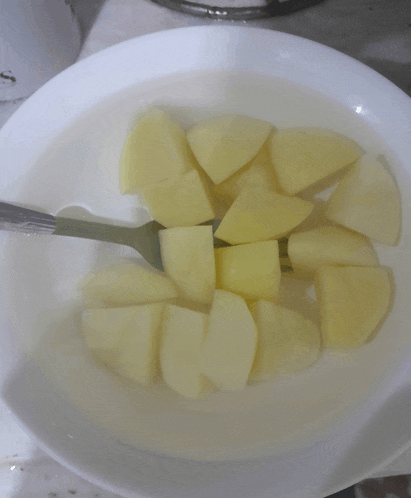 a plate of sliced potatoes with a fork in them