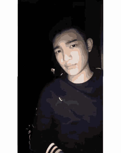 a young man is taking a selfie in the dark .
