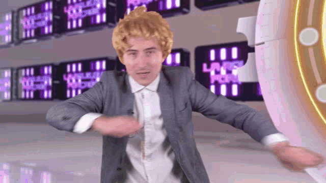 a man in a suit and white shirt is dancing in front of a wall with a sign that says ' las vegas '