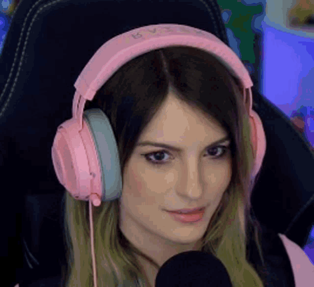 a woman wearing pink headphones and a microphone .