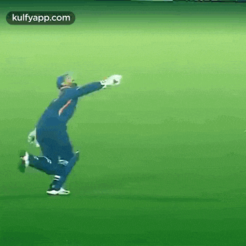 a man in a blue uniform is running on a green field .