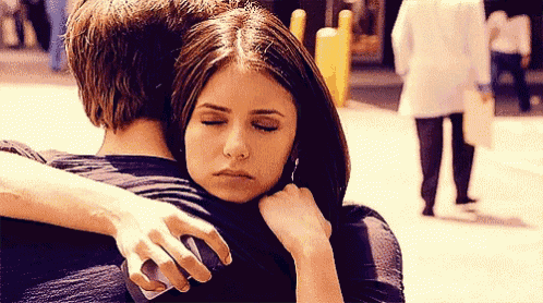 a woman hugging a man with her eyes closed