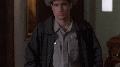 a man wearing a cowboy hat and a black jacket is crying