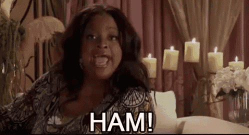 a woman is sitting on a couch in a room with candles and screaming .