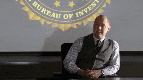 a man sits at a table in front of a screen that says bureau of invest