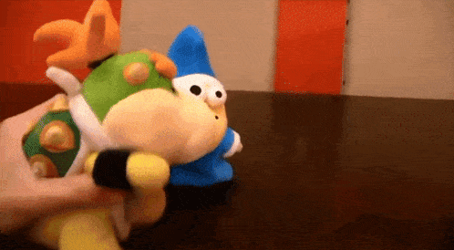 a person is holding a stuffed toy on a table .