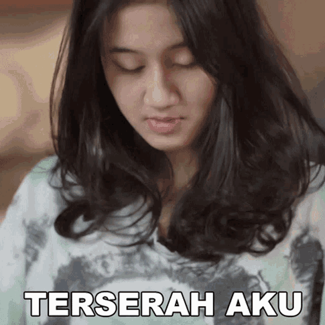 a woman with her eyes closed has a sticker that says terserah aku on her face