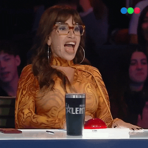 a woman wearing glasses sits in front of a cup that says talent