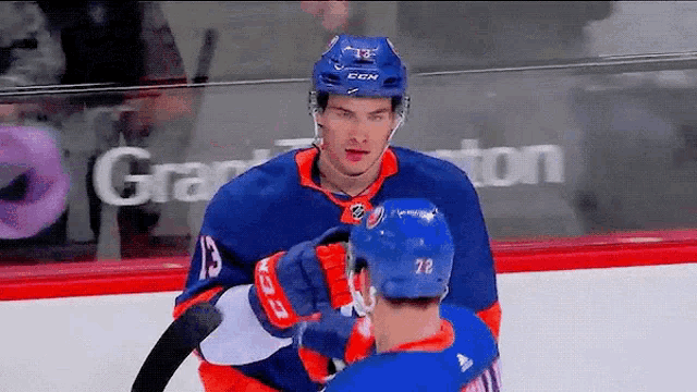 a hockey player with the number 78 on his helmet is hugging another player
