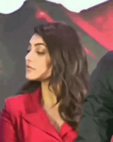 a woman in a red jacket is being touched by a man .