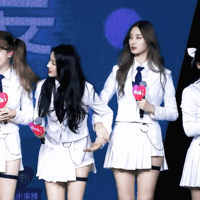 a group of girls are holding microphones with the word doki on them