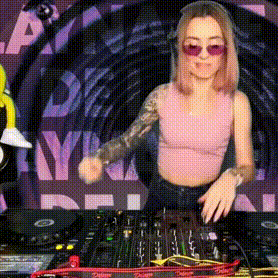 a woman in a pink tank top and sunglasses is playing music on a mixer .