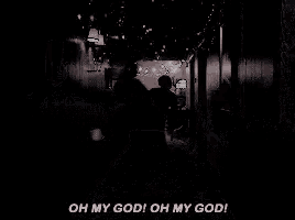 a man is walking down a hallway with christmas lights on the walls .