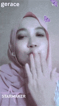 a woman wearing a pink hijab blowing a kiss with the word gerace starmaker behind her